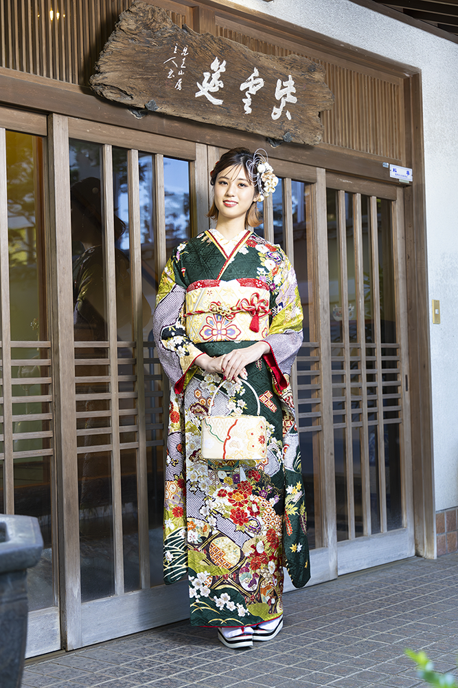 王道クラシカルな深緑×金駒刺繍の振袖を着て、白小物を持った女性