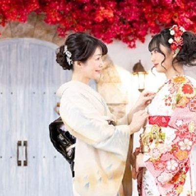 着物姿の女性と振袖姿の女性が向かい合って微笑む様子