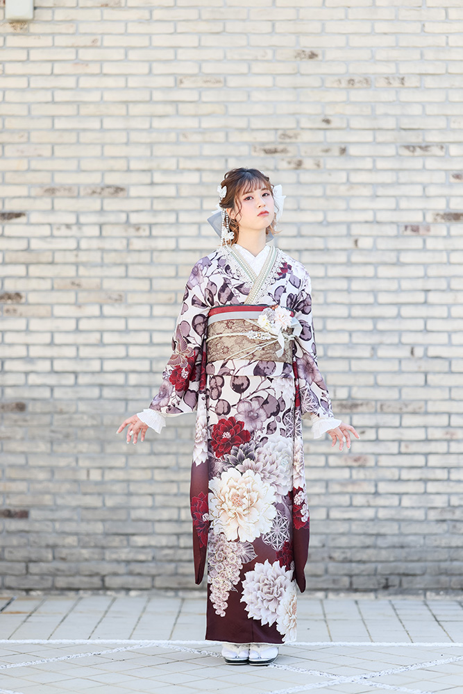 深みのある紫の振袖に大輪の花柄の帯を合わせた大人っぽいコーデ