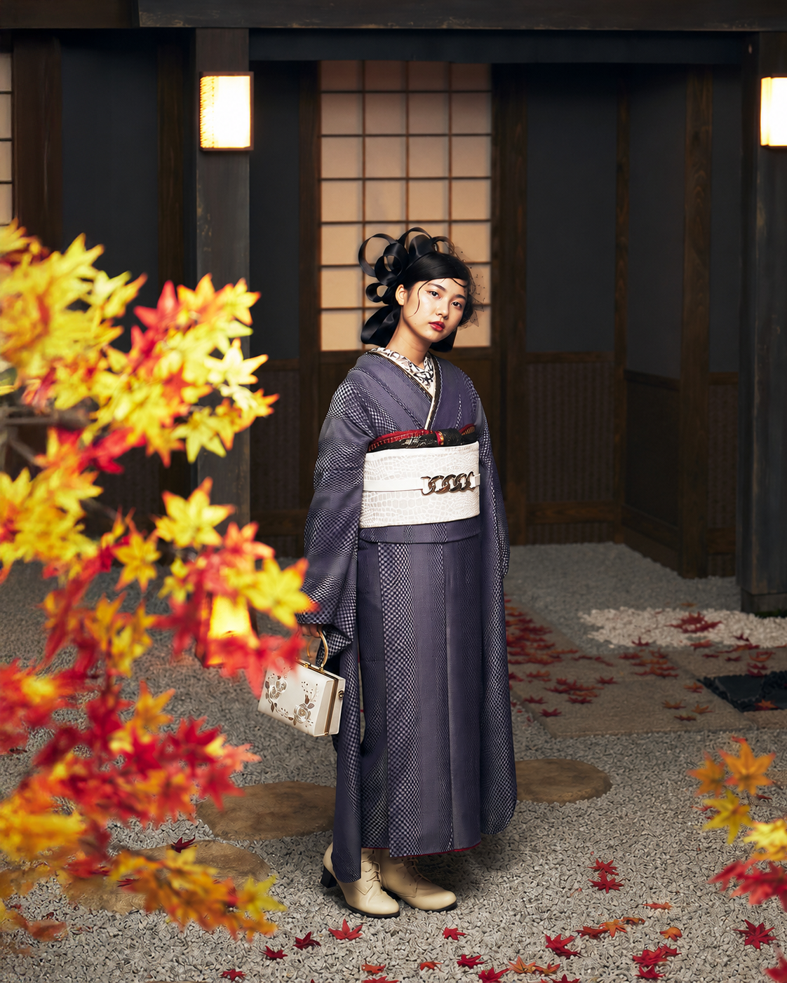 紅葉のセットの前で振袖姿で立つ女性