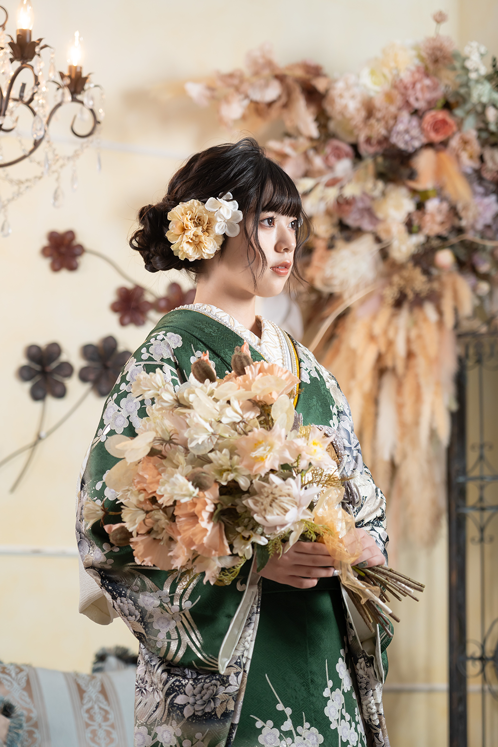 深緑の振袖を着て花束を持つ女性の上半身