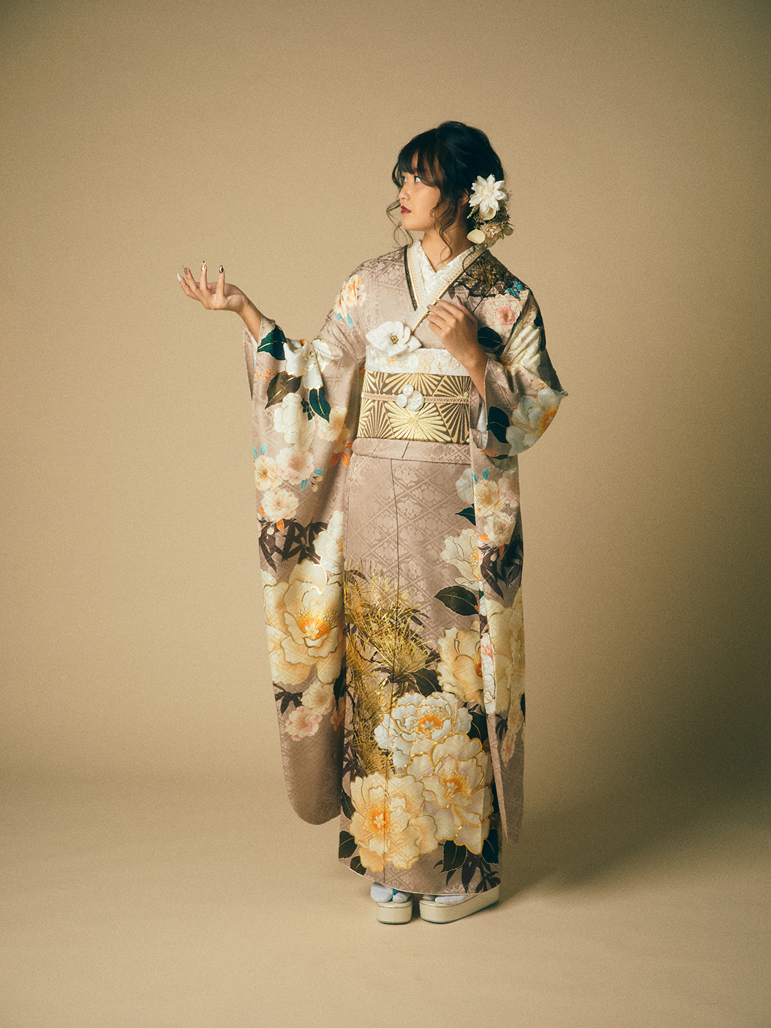 ピンクベージュの振袖に大輪の花柄とゴールドの帯を合わせたコーデ